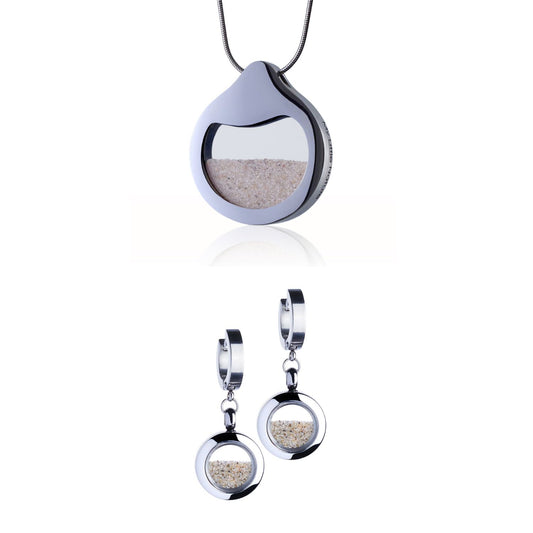 Beach Sand Jewelry Set with a designer necklace by Barbora-Adamonyte Keidune and dangle huggie earrings in stainless steel, featuring real beach sand under glass. Symbolizes serenity and living in the moment.