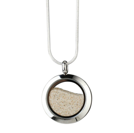 andmade beach sand amulet with genuine beach sand encased under glass and set in stainless steel, symbolizing the flow of time and the importance of cherishing the present.