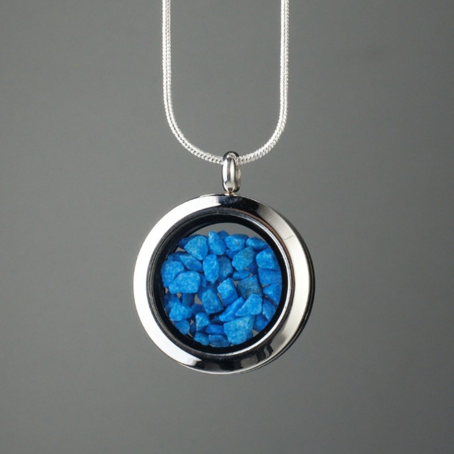 Handmade blue stones amulet with genuine blue stones encased in glass and set in stainless steel, symbolizing inner peace, clarity, and strength.