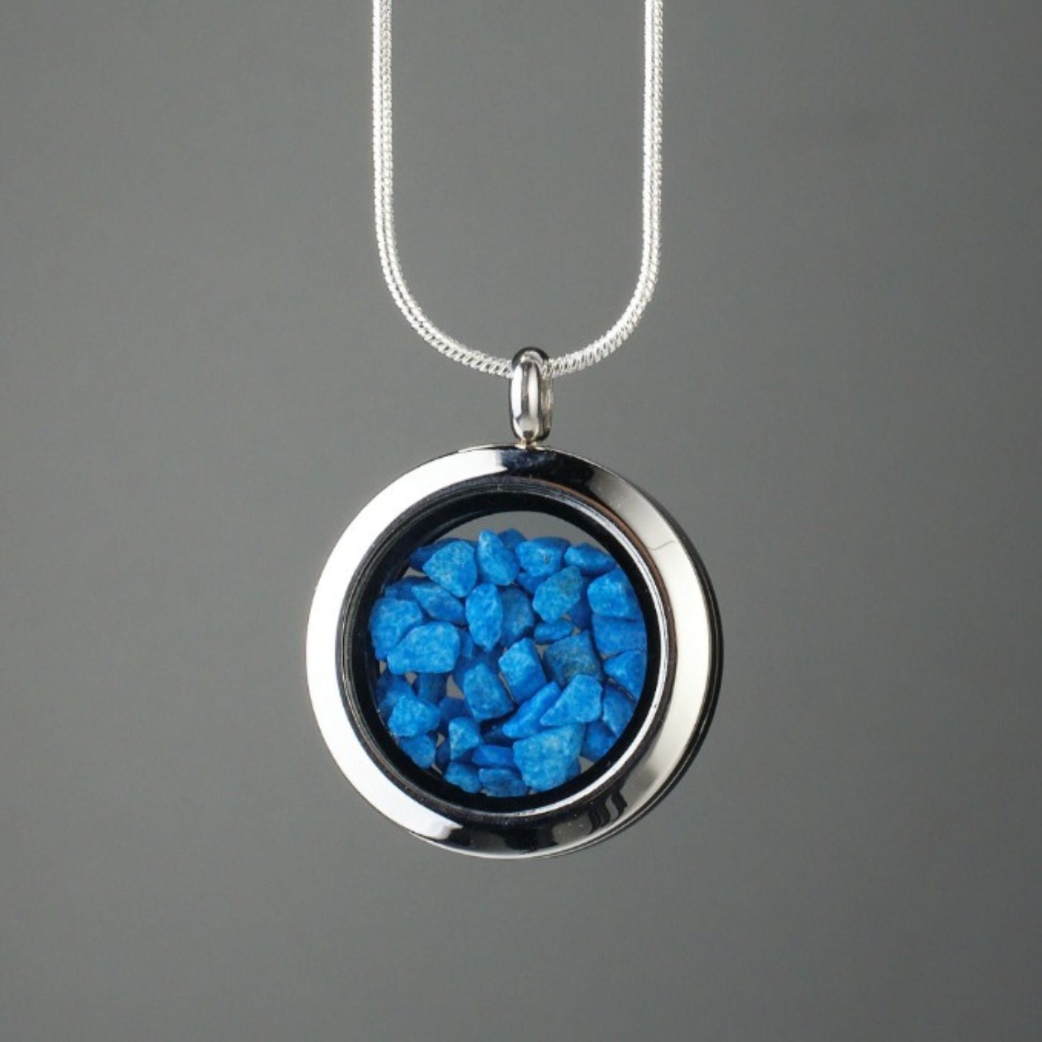 Handmade blue stones amulet with genuine blue stones encased in glass and set in stainless steel, symbolizing inner peace, clarity, and strength.