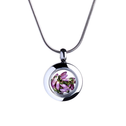 A round silver color  pendant necklace with a small glass dome containing purple flower petals on a snake style chain