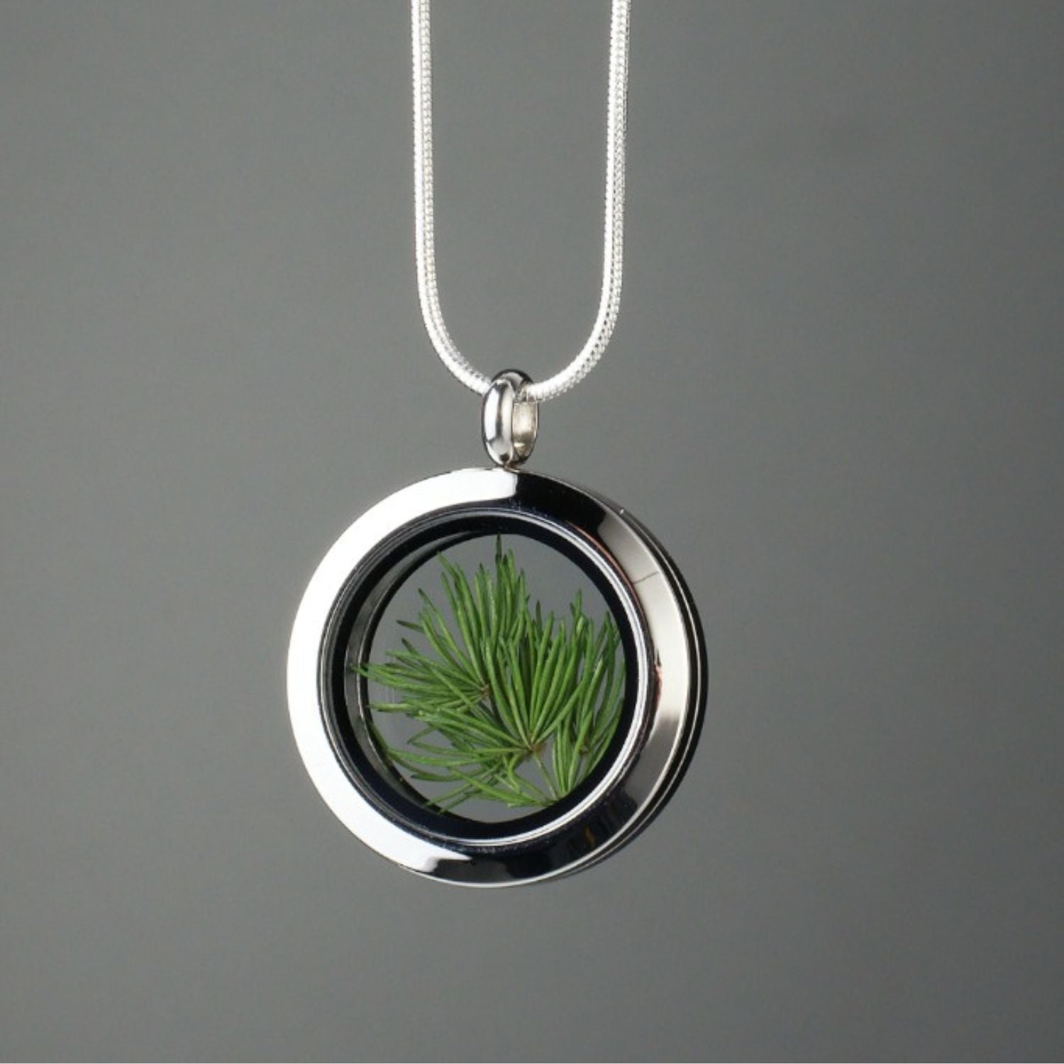 Handmade Pine Needles Amulet with genuine pine needles encased in glass and set in stainless steel, symbolizing eternal youth, vitality, and boundless energy.